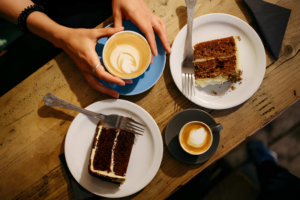 two cups of coffee and two slices of cakes on a table
